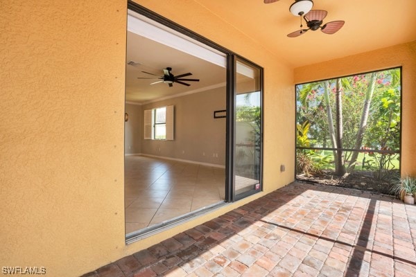 unfurnished sunroom with ceiling fan