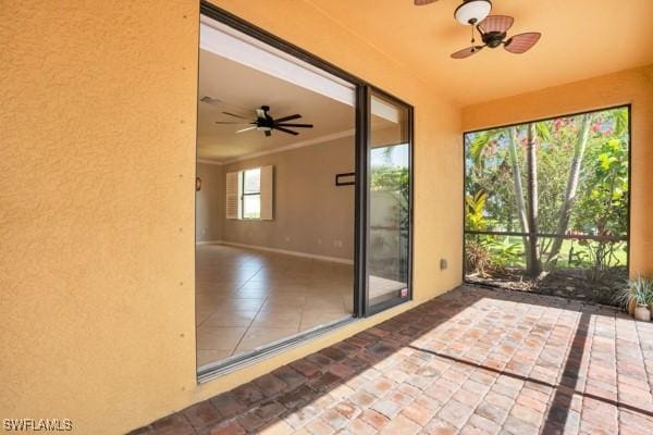 unfurnished sunroom featuring a ceiling fan