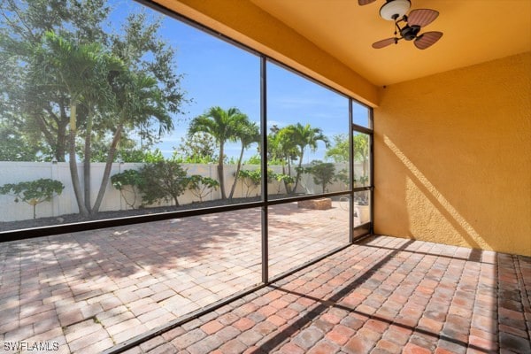 unfurnished sunroom with ceiling fan