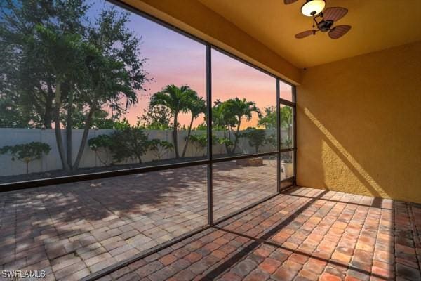 unfurnished sunroom featuring ceiling fan