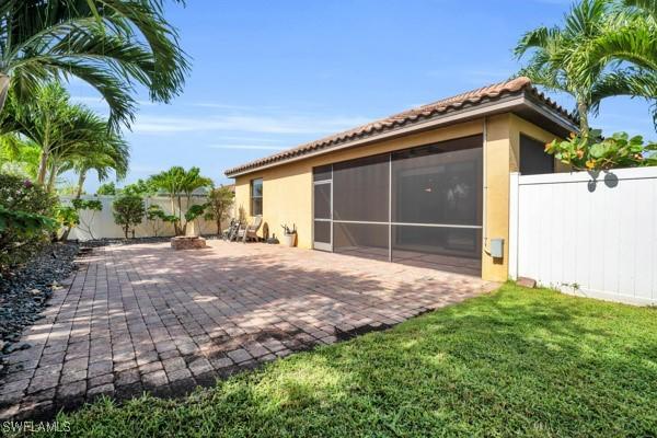 back of house with a patio area, a sunroom, and a yard