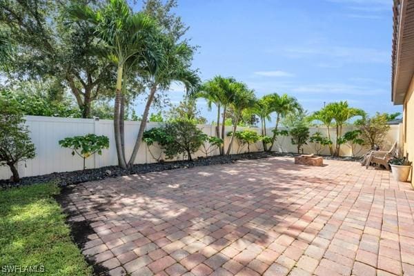 view of patio featuring a fenced backyard and a fire pit