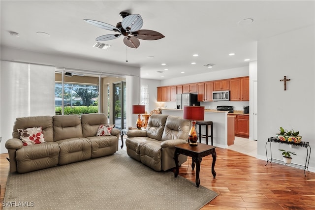 living room with light hardwood / wood-style flooring and ceiling fan