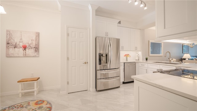 kitchen with white cabinets, stainless steel appliances, ornamental molding, and sink