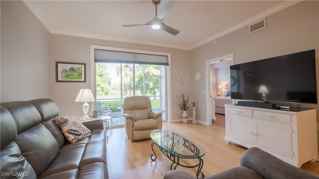 living room with ceiling fan, ornamental molding, and light wood-type flooring