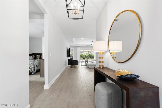 foyer entrance featuring a chandelier and light hardwood / wood-style floors