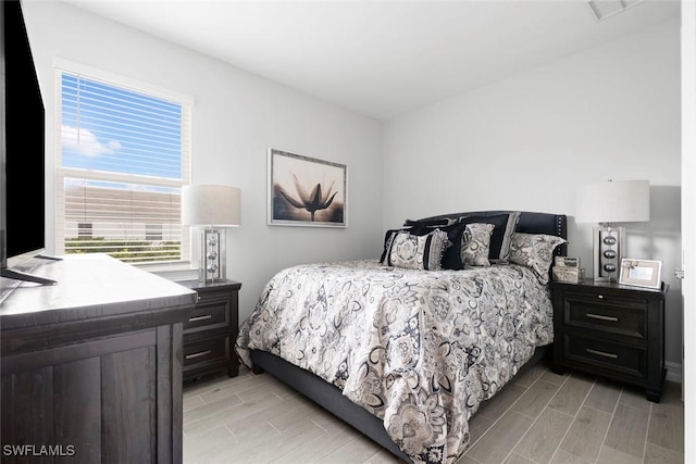 bedroom featuring wood finish floors and visible vents