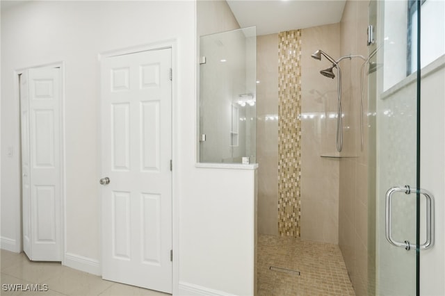 bathroom with an enclosed shower and tile patterned floors