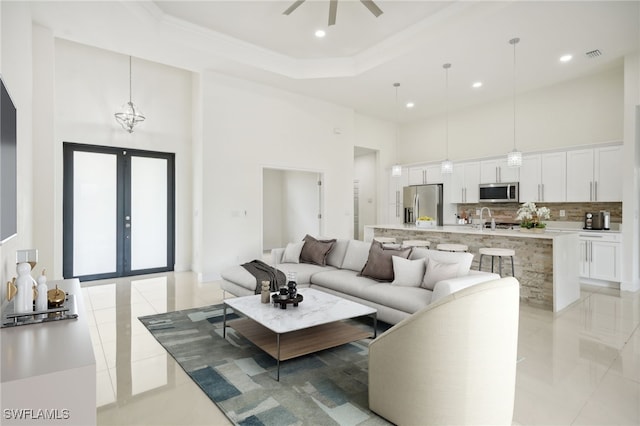 living room with light tile patterned floors, french doors, and a towering ceiling