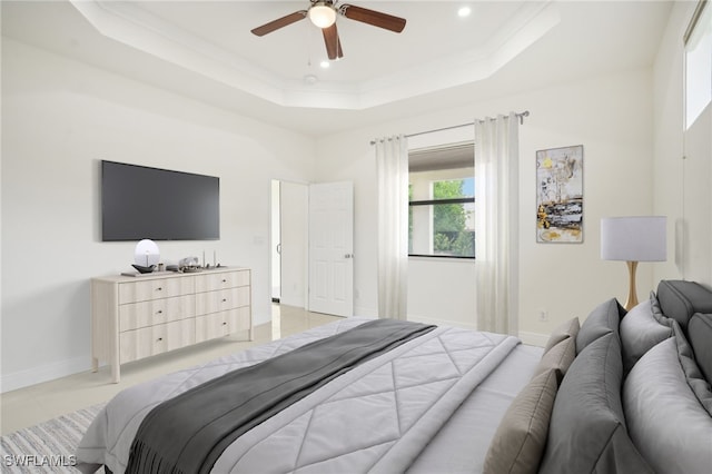 tiled bedroom featuring ceiling fan and a raised ceiling