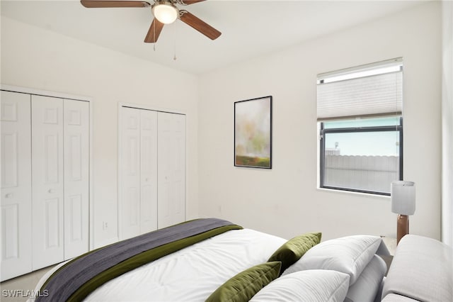 bedroom with ceiling fan and multiple closets