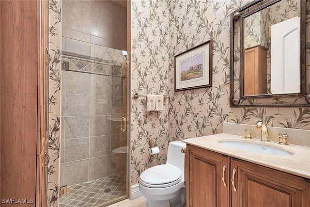 bathroom with a shower with door, vanity, and toilet