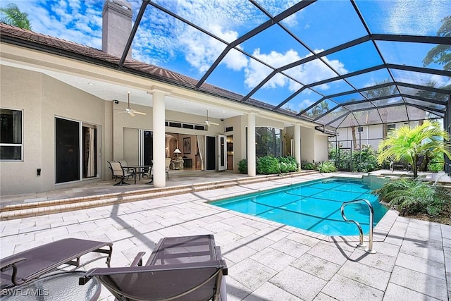 view of swimming pool featuring ceiling fan, a patio, and glass enclosure