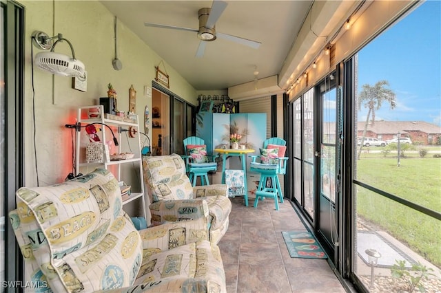 sunroom / solarium featuring ceiling fan