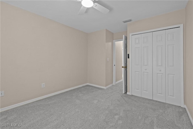 unfurnished bedroom featuring light carpet, ceiling fan, and a closet