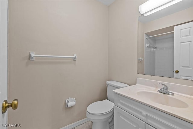 bathroom featuring walk in shower, vanity, and toilet