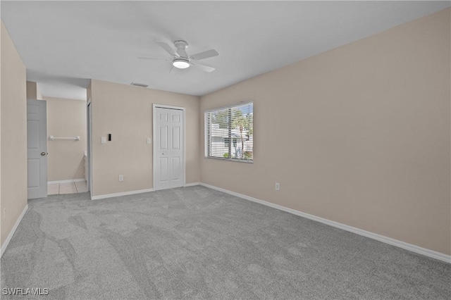 unfurnished bedroom featuring light colored carpet, ceiling fan, and a closet