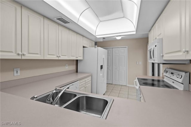 kitchen with white cabinetry, white appliances, light tile patterned flooring, and sink