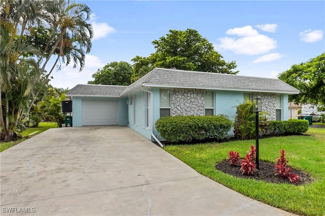 view of front facade with a shingled roof, a front lawn, stucco siding, driveway, and an attached garage