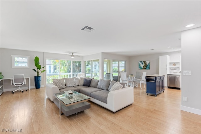 living room featuring a healthy amount of sunlight, ceiling fan, and light wood-type flooring