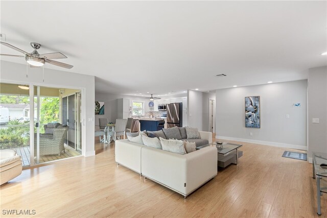 living room featuring light hardwood / wood-style flooring and ceiling fan