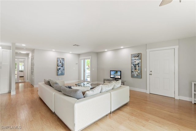 living room featuring ceiling fan and light hardwood / wood-style floors