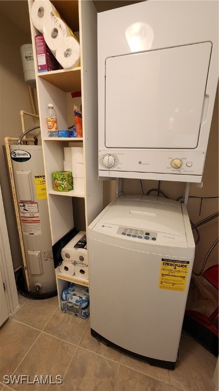 laundry area featuring electric water heater, stacked washer and dryer, and light tile patterned floors