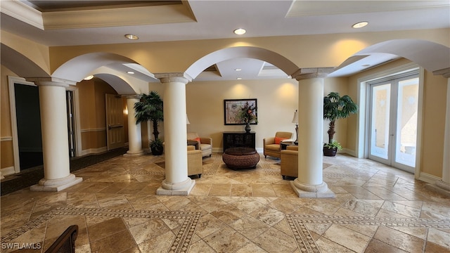 interior space with light tile patterned flooring, decorative columns, crown molding, and a raised ceiling