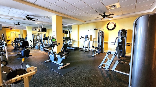 gym featuring a drop ceiling and ceiling fan