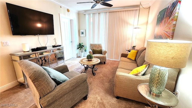 carpeted living room with ceiling fan and ornamental molding