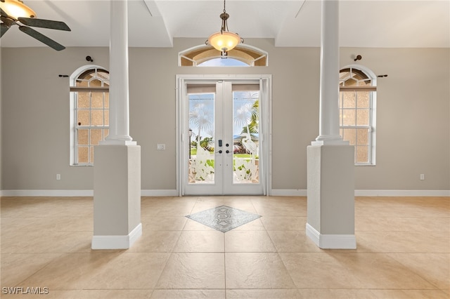 foyer with french doors, ornate columns, light tile patterned floors, and ceiling fan