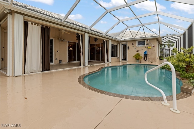 view of pool featuring a lanai, a patio, and ceiling fan