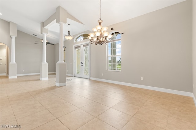 tiled spare room with decorative columns, french doors, ceiling fan with notable chandelier, and lofted ceiling