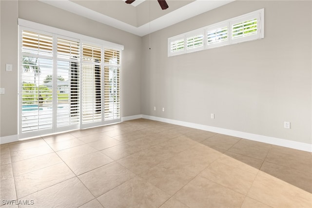 tiled spare room featuring ceiling fan