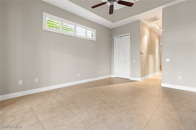 tiled spare room with a high ceiling and ceiling fan