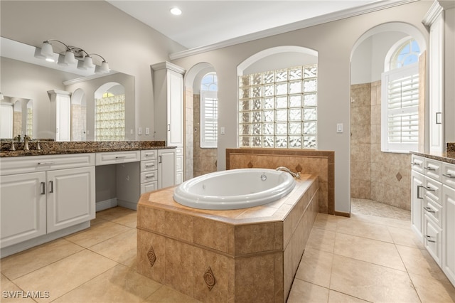 bathroom with vanity, tiled tub, and tile patterned flooring