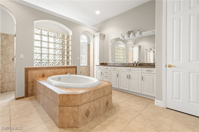 bathroom featuring vanity, tiled tub, and tile patterned flooring