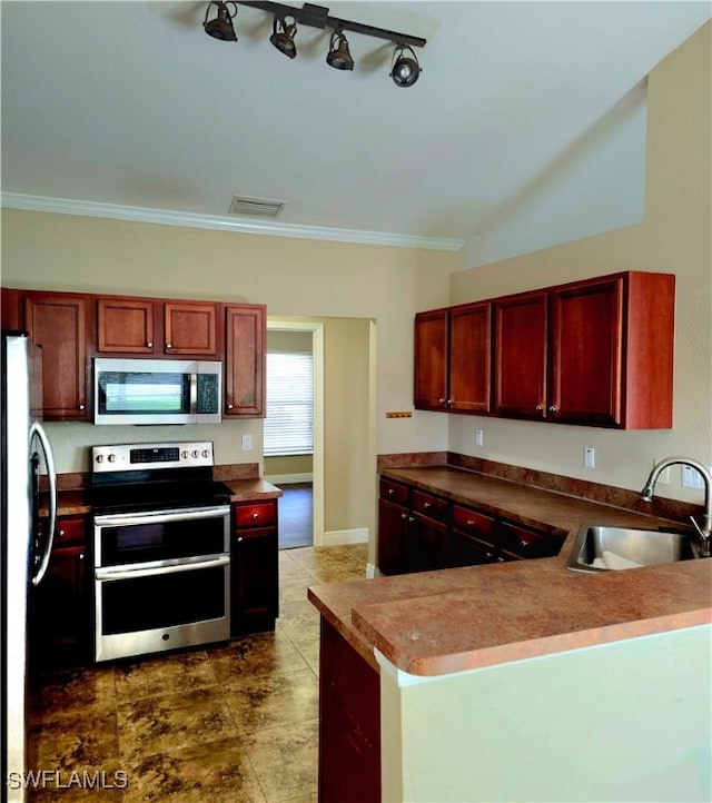 kitchen with appliances with stainless steel finishes, sink, rail lighting, crown molding, and tile patterned floors