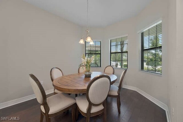 dining space featuring dark hardwood / wood-style flooring and a chandelier