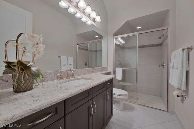 bathroom featuring a shower with door, vanity, toilet, and tile patterned floors