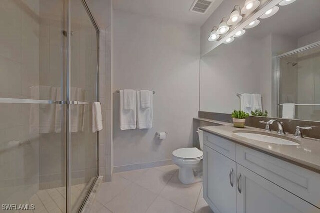 bathroom with tile patterned flooring, vanity, toilet, and a shower with shower door