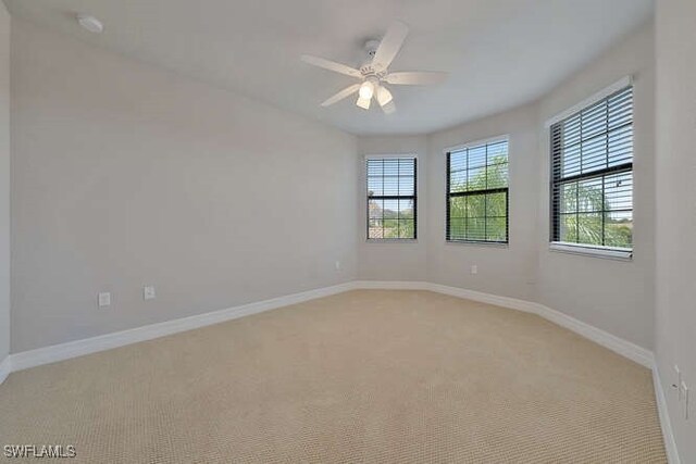 unfurnished room featuring light colored carpet and ceiling fan