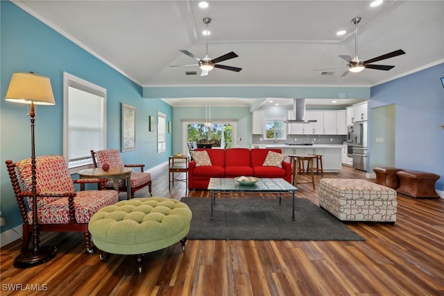 living room with ceiling fan with notable chandelier, crown molding, and hardwood / wood-style floors