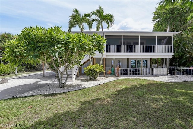 8335 Main St, Bokeelia, FL 33922 - rear view of property with a lawn, stairway, and a sunroom
