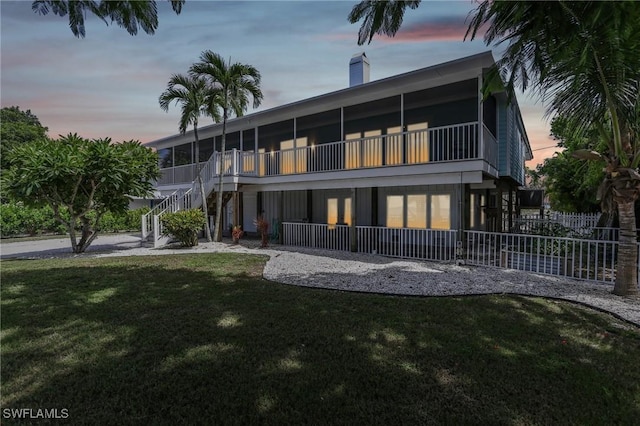 8335 Main St, Bokeelia, FL 33922 - back of house featuring a lawn, stairway, a chimney, and fence