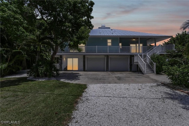 8335 Main St, Bokeelia, FL 33922 - beach home with a chimney, stairway, metal roof, a garage, and driveway
