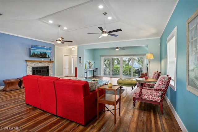 living room featuring a stone fireplace, dark wood-type flooring, ceiling fan, and lofted ceiling