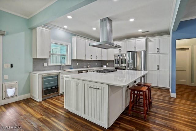8335 Main St, Bokeelia, FL 33922 - kitchen featuring beverage cooler, island range hood, stainless steel appliances, a sink, and crown molding