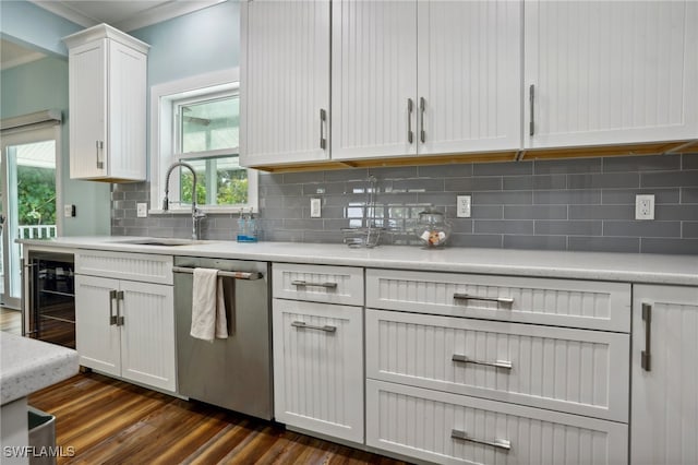 kitchen with tasteful backsplash, sink, stainless steel dishwasher, dark hardwood / wood-style floors, and white cabinetry