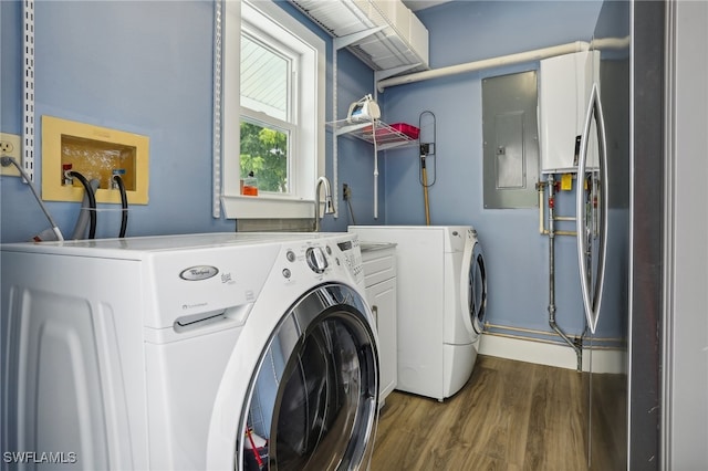 laundry area with wood-type flooring, electric panel, washing machine and dryer, and cabinets